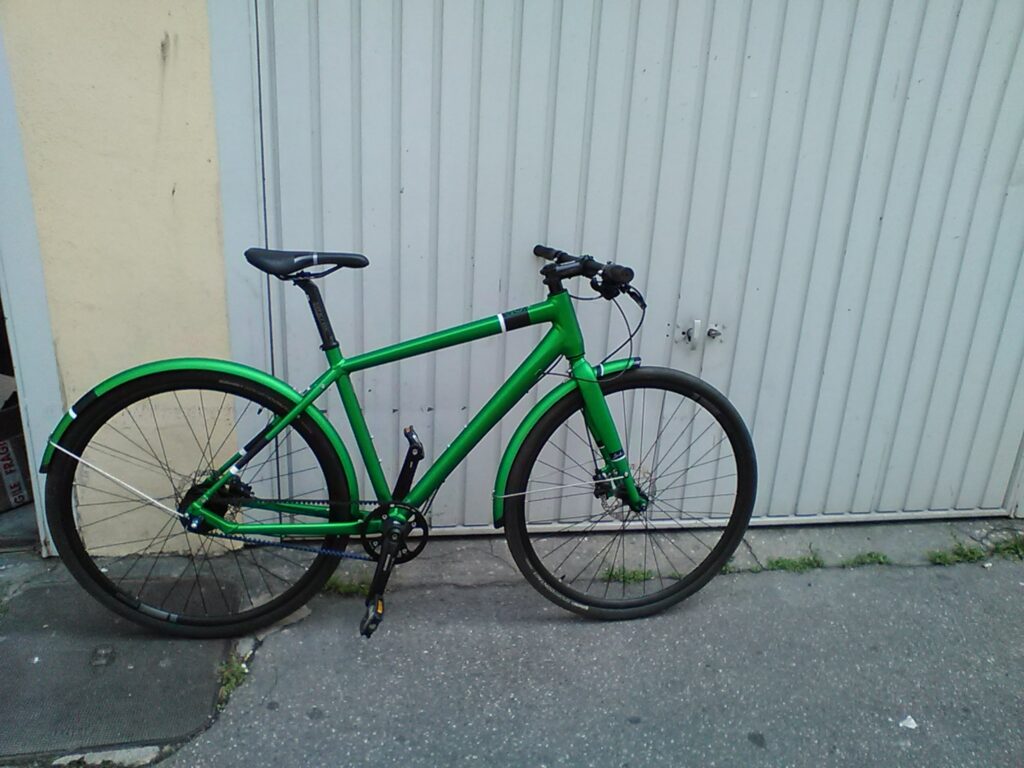 A flashy green (including mudguards) brand new on a white garage door bike